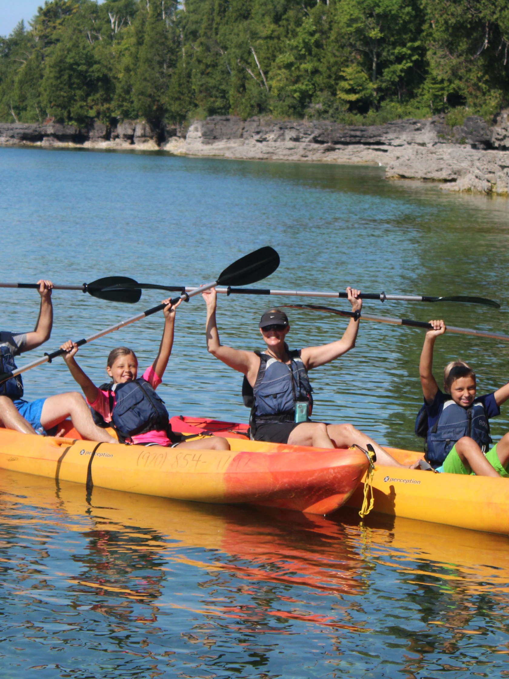 Kayakers raising their paddles with both hands on Lake Michigan
