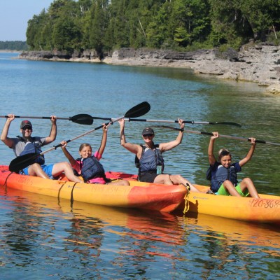 Kayakers raising their paddles with both hands on Lake Michigan