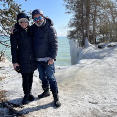 a couple of people that are standing in the snow at cave point on an ebike tour
