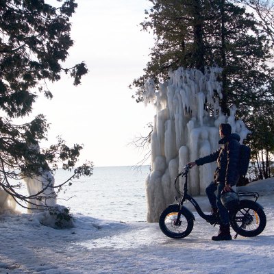 a man riding a motorcycle on the side of a snow covered slope