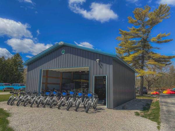 a garage with a bunch of ebikes in front of it.