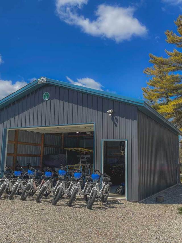 a garage with a bunch of ebikes in front of it.