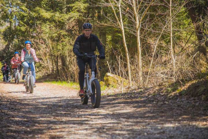 a man riding a fat tire ebike on a gravel path near whitefish bay dunes state park