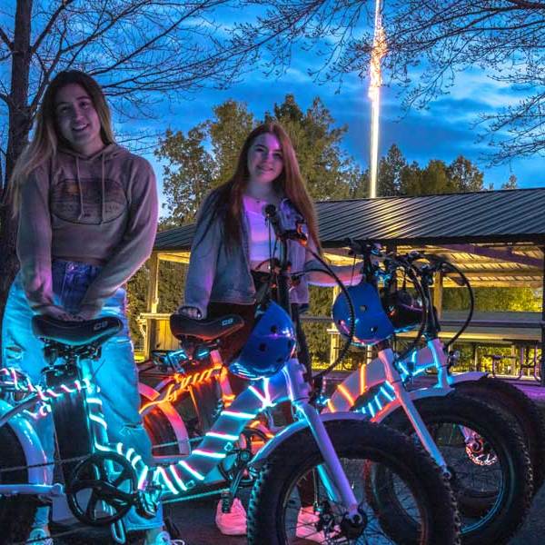 2 girls standing near e-bikes