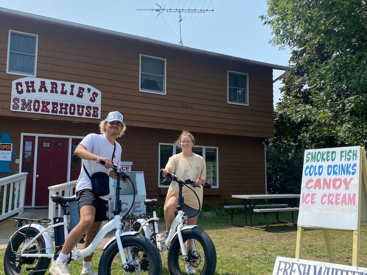 a group of people standing around a motorcycle in front of a house
