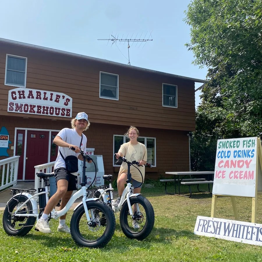 a group of people standing around a motorcycle in front of a house